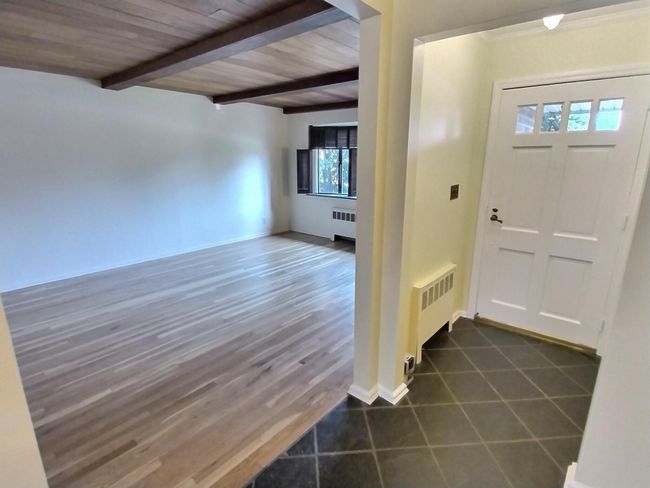 Foyer entrance with radiator and wood ceiling with exposed beams | Image 7