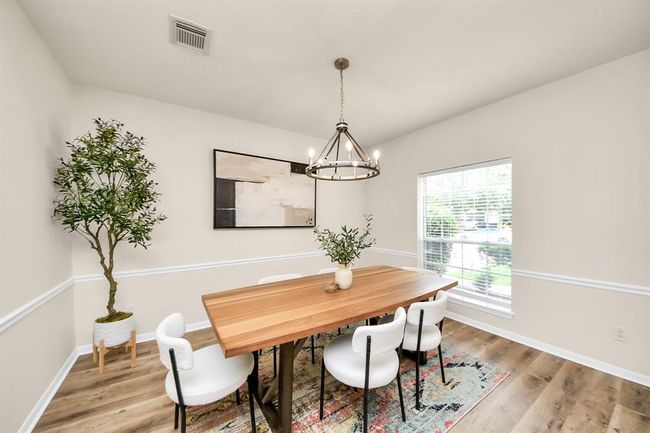 Another view of the formal dining room showcases its modern, open layout and warm, inviting atmosphere. Bathed in natural light, it’s the perfect space to gather and enjoy. | Image 7