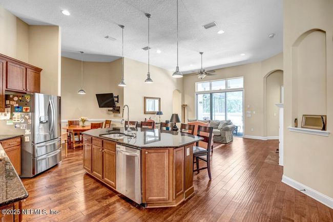 Large open kitchen overlooking family room and view to pool and backyard | Image 15