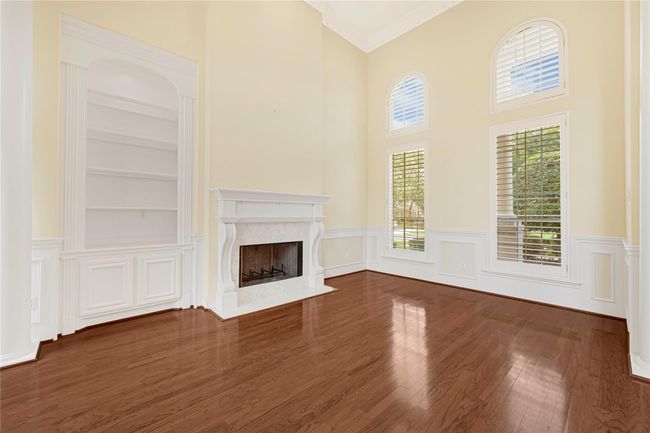 Cozy living area featuring a charming fireplace and elegant custom built-ins. | Image 9