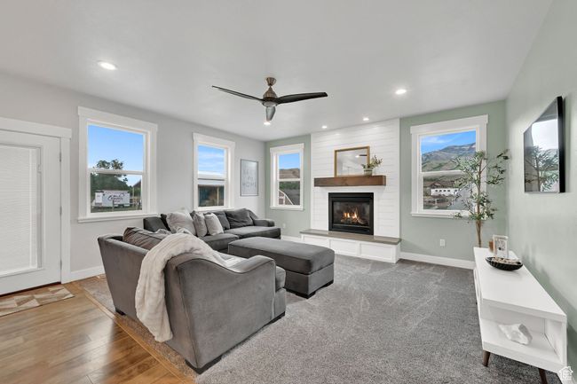 Living room with ceiling fan, a large fireplace, recessed lighting, and wood finished floors | Image 18