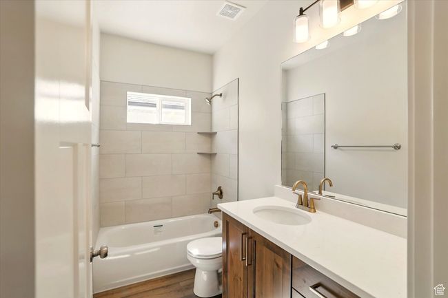Full bathroom featuring toilet, vanity, shower / bath combination, and wood finished floors | Image 27