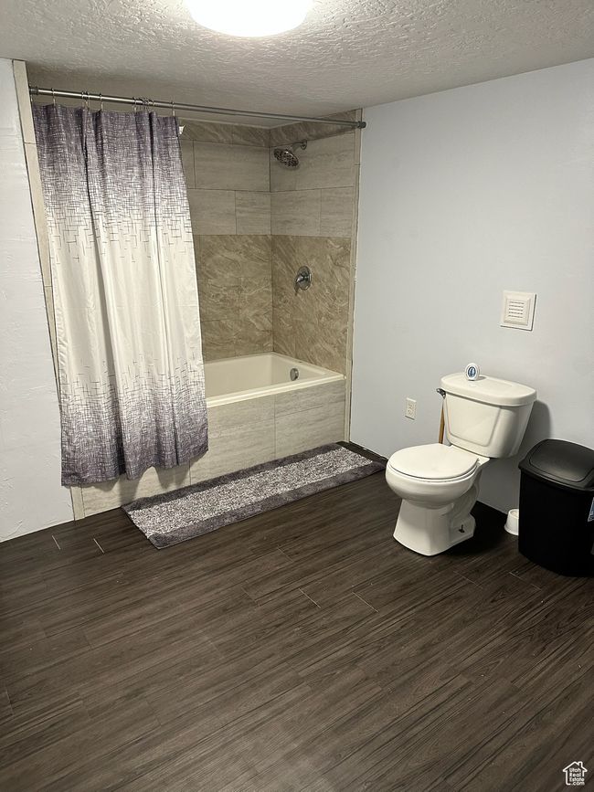 Bathroom with a textured ceiling, toilet, and shower / bath combo with shower curtain | Image 28