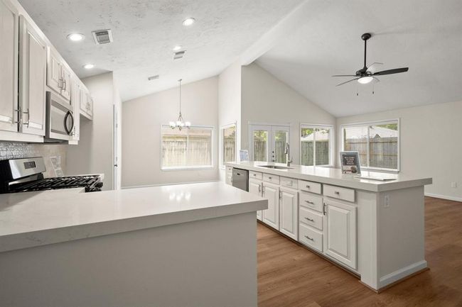 Enjoy cooking in this fully upgraded kitchen featuring elegant quartz countertops, a sleek backsplash | Image 6