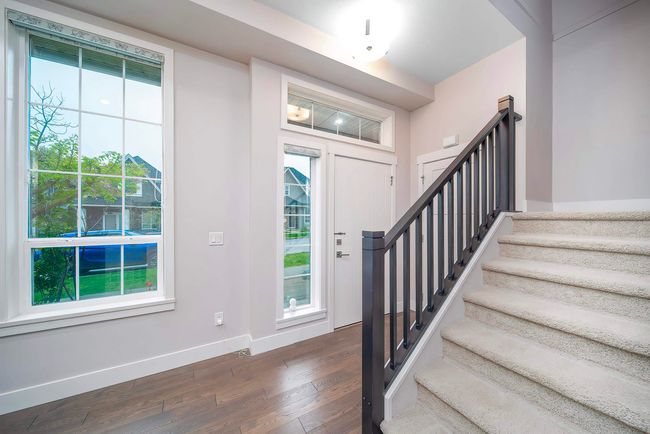Entryway with dark wood finished floors, stairs, and baseboards | Image 15
