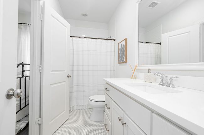 Jack and Jill bathroom with vanity, toilet, curtained shower, and tile patterned floors | Image 31