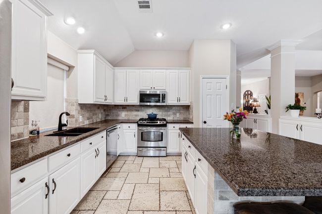 Open kitchen with stainless steel appliances, and view of pool | Image 15