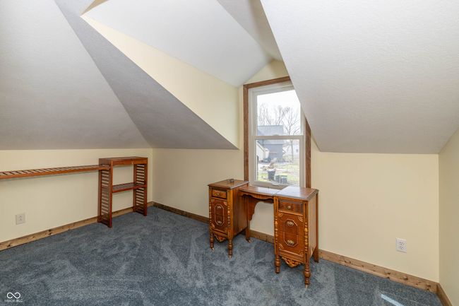 carpeted office space featuring lofted ceiling, baseboards, and a textured ceiling | Image 18