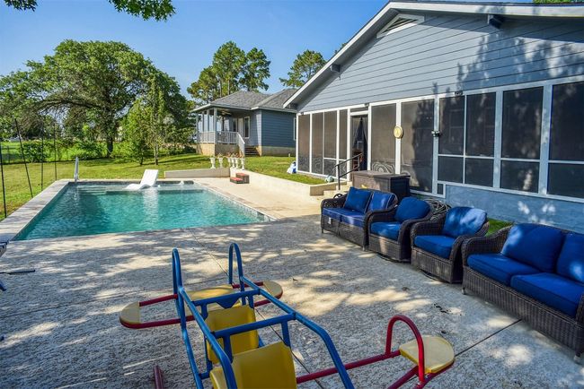 Outdoor pool featuring outdoor lounge area, a sunroom, and a patio area | Image 15