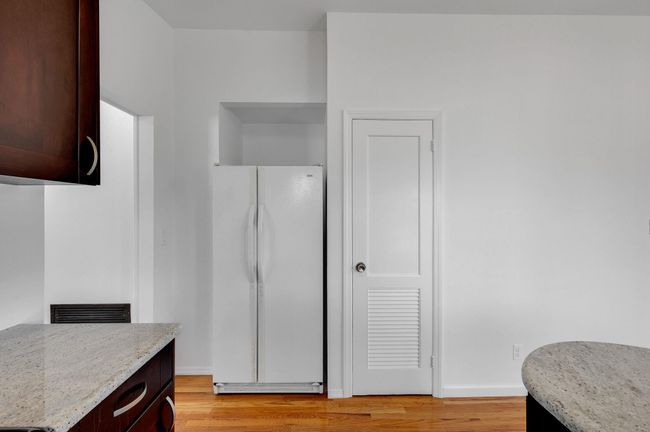 Kitchen featuring light stone countertops, a sink, stainless steel appliances, and light wood-type flooring | Image 7