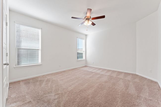 Spare room with baseboards, light colored carpet, and ceiling fan | Image 8