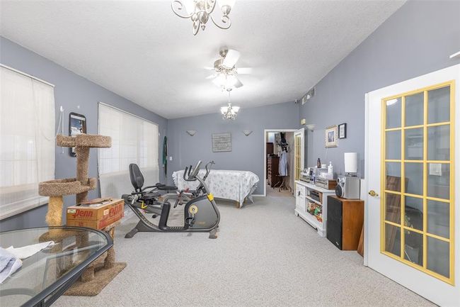 Bedroom with carpet floors, a chandelier, and a textured ceiling | Image 28