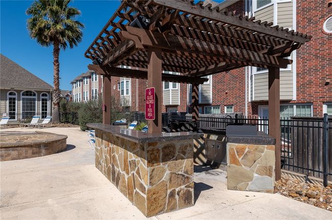 Pool area has an outdoor pergola featuring a grill | Image 30