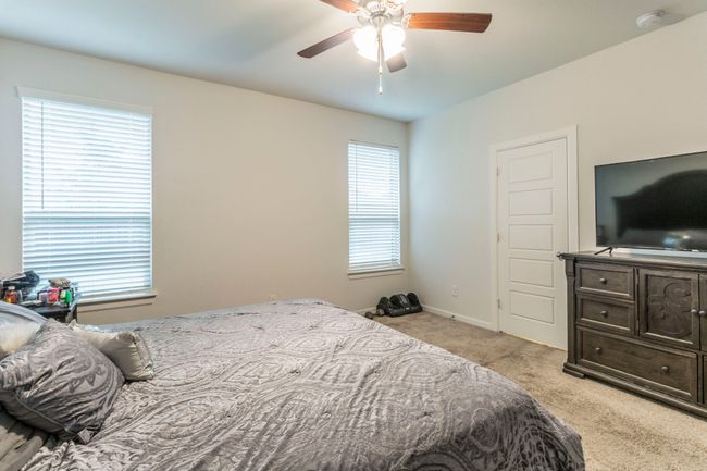 Bedroom featuring light colored carpet, baseboards, and a ceiling fan | Image 9