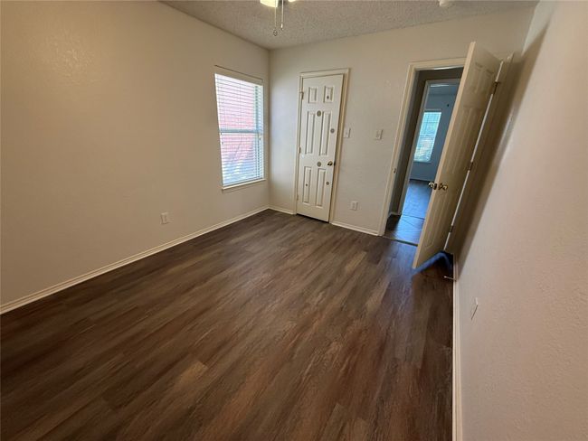Unfurnished bedroom featuring dark wood-style floors, a textured ceiling, and baseboards | Image 23
