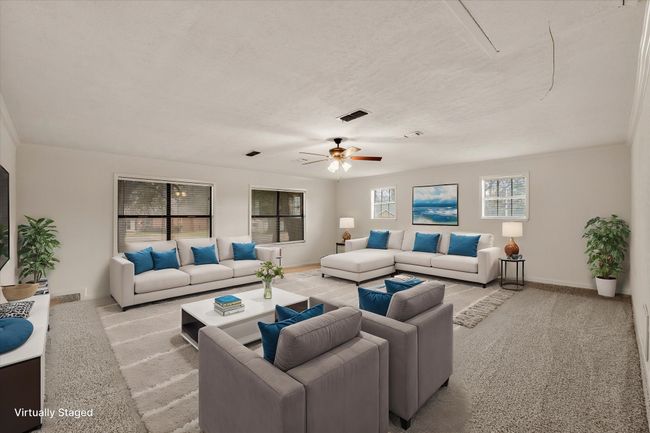 Living room with light carpet, ceiling fan, and a textured ceiling | Image 10