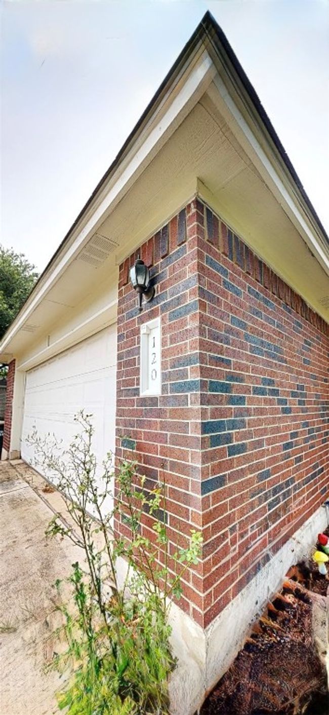 View of property exterior with brick siding, concrete driveway, and a garage | Image 4