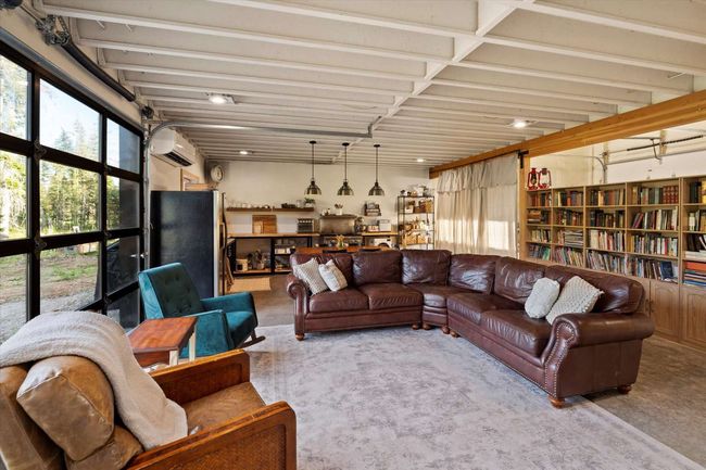 Carpeted living room featuring a wall unit AC and plenty of natural light | Image 23