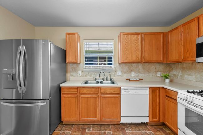 Kitchen featuring stainless steel appliances, backsplash, and light countertops | Image 20