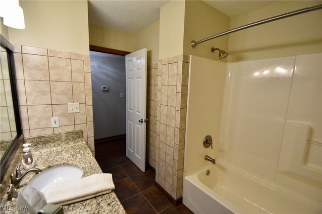 Bathroom featuring tile walls, vanity, shower / washtub combination, and tile patterned floors | Image 19