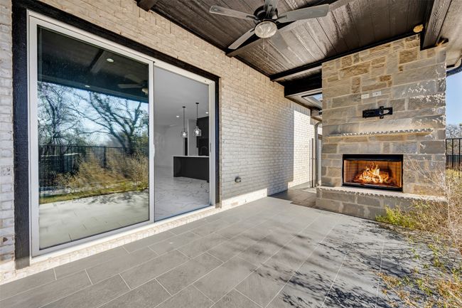 View of patio / terrace with an outdoor stone fireplace and ceiling fan | Image 19