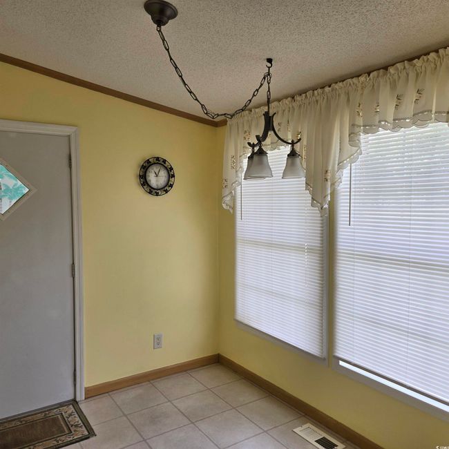 Breakfast Nook featuring light tile patterned flooring, a textured ceiling, and ornamental molding | Image 19