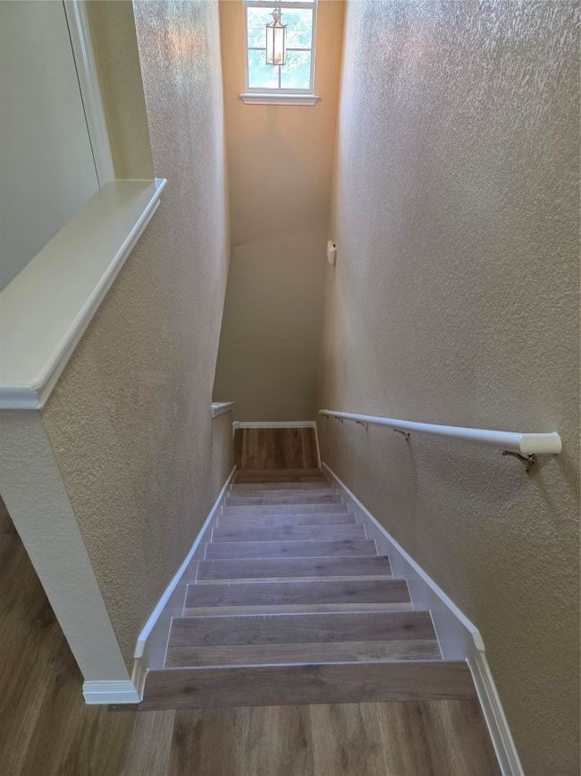 Stairway featuring a textured wall and wood finished floors | Image 17