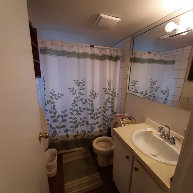 Bathroom with vanity, toilet, visible vents, decorative backsplash, and tile walls | Image 12