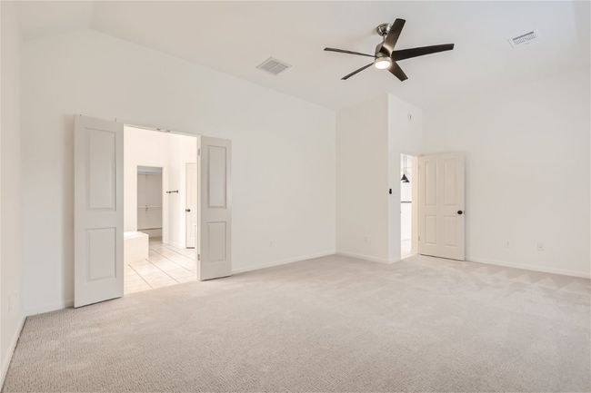 Unfurnished room featuring light colored carpet, a ceiling fan, high vaulted ceiling, and baseboards | Image 19