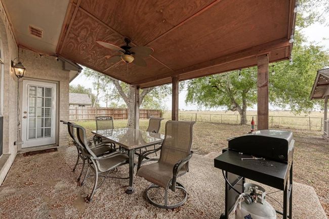 Fenced backyard with outdoor dining area, ceiling fan, grilling area, and a patio area | Image 30