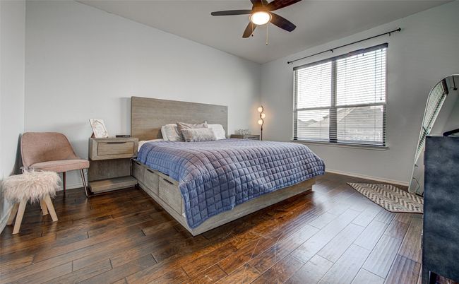 Bedroom featuring wood finished floors, a ceiling fan, and baseboards | Image 12