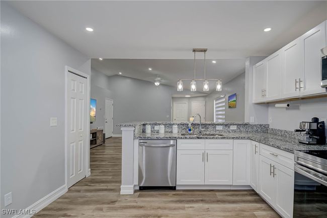 Kitchen with dishwasher, a sink, a peninsula, white cabinets, and recessed lighting | Image 8