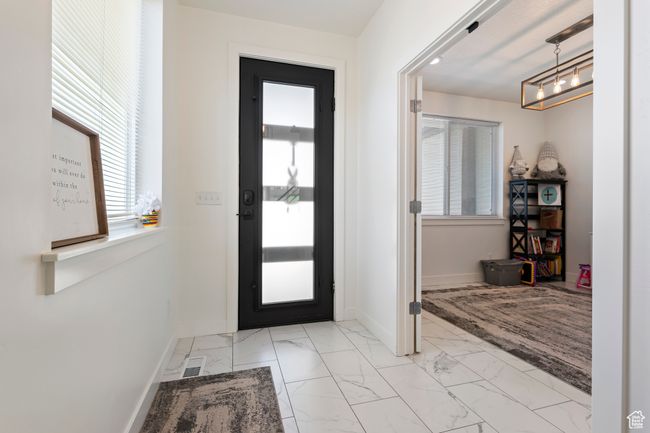 Foyer entrance featuring marble finish floor, an inviting chandelier, visible vents, and baseboards | Image 8