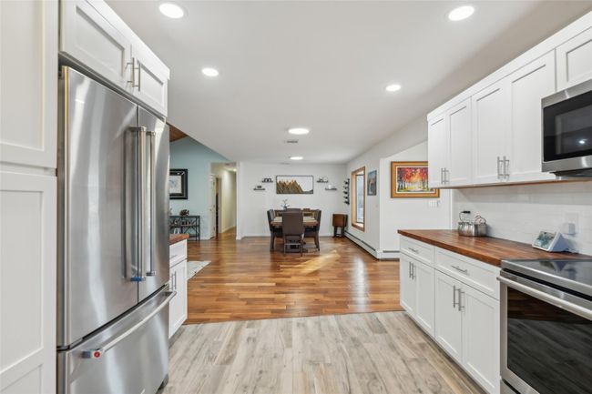 Kitchen with light wood finished floors, wooden counters, recessed lighting, appliances with stainless steel finishes, and tasteful backsplash | Image 14