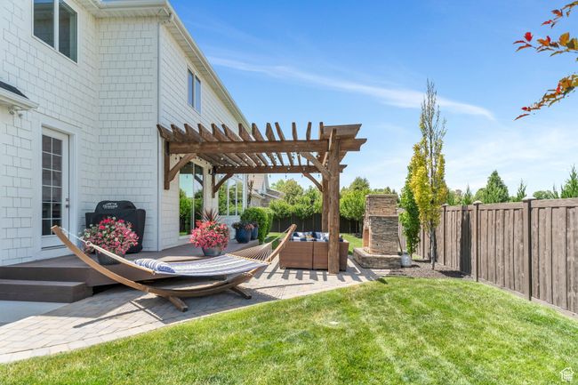 Fenced backyard with a patio, a pergola, and an outdoor living space with a fireplace | Image 75