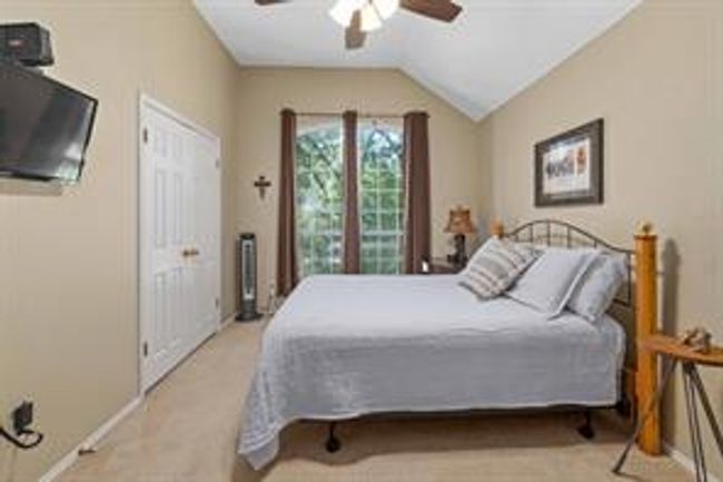 Bedroom featuring carpet flooring, ceiling fan, and vaulted ceiling | Image 29
