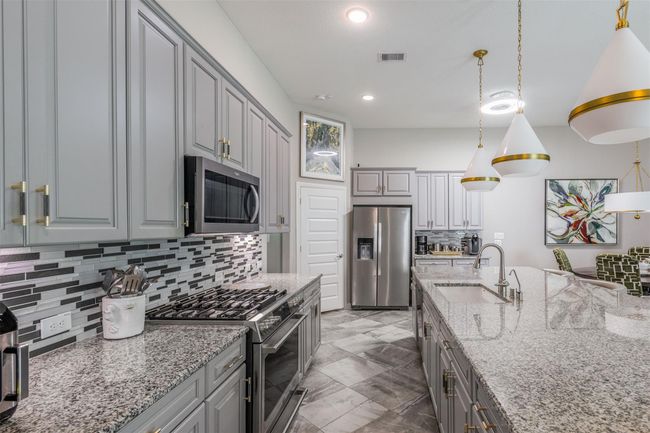 The kitchen offers generous counter space, modern appliances, and ample storage for a tidy, efficient cooking area. | Image 17