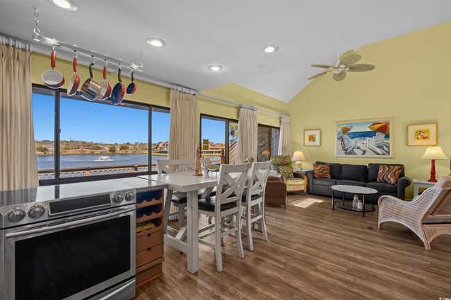 Kitchen featuring wood finished floors, lofted ceiling, ceiling fan, a water view, and stainless steel electric stove | Image 18