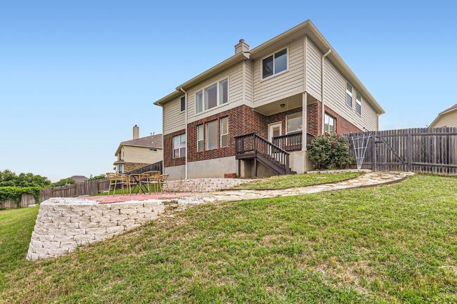 Rear view of house with brick siding, a chimney, and stairs | Image 26