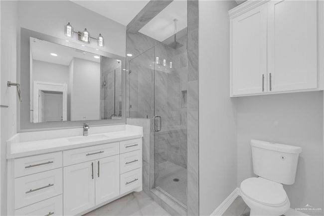 Bathroom with baseboards, toilet, vanity, a marble finish shower, and marble finish floor | Image 18