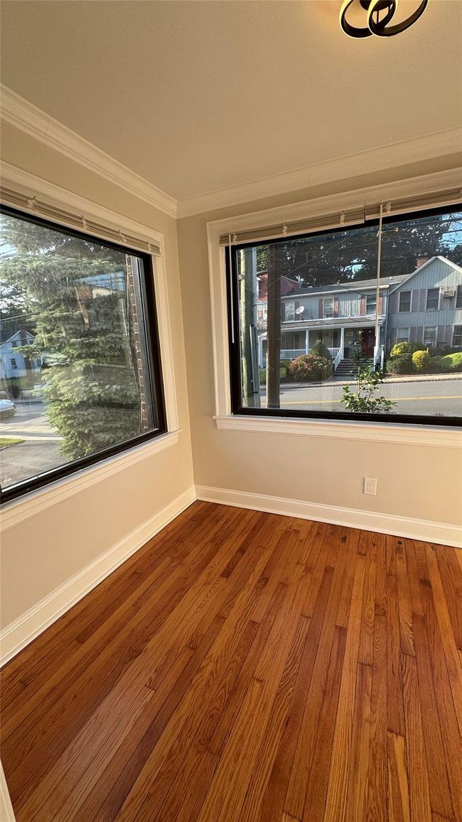 Spare room featuring crown molding and wood finished floors | Image 13