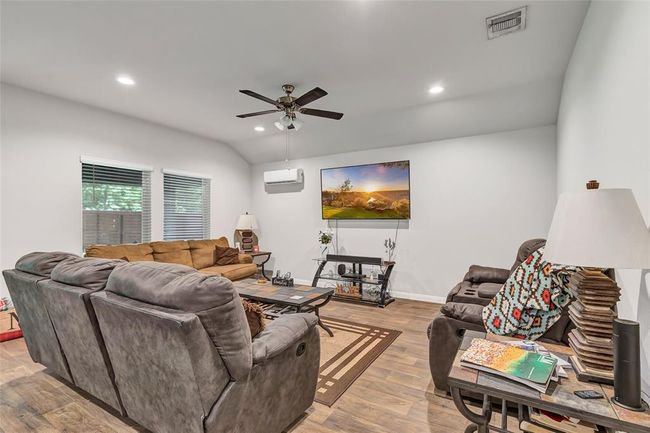 Living room has high ceiling and is large enough to accommodate plenty of furniture. | Image 21