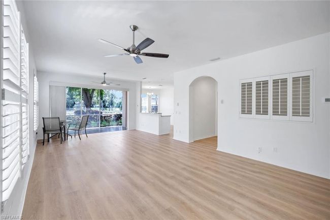 Unfurnished living room featuring ceiling fan, light wood-type flooring, and arched walkways | Image 5