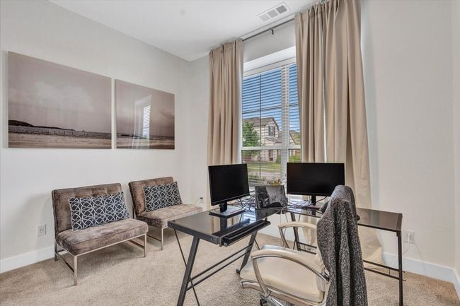 Home office with a big window that lets in natural light and a view of the street. | Image 6