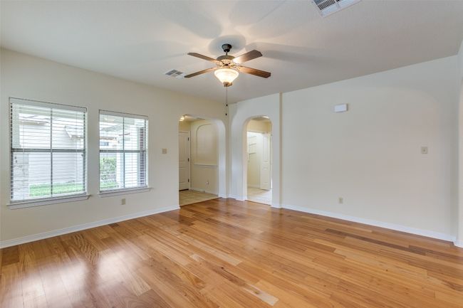 Unfurnished room featuring arched walkways, a ceiling fan, and light wood-type flooring | Image 5