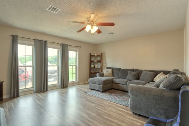 Living area featuring ceiling fan, a textured ceiling, and light wood-type flooring | Image 23