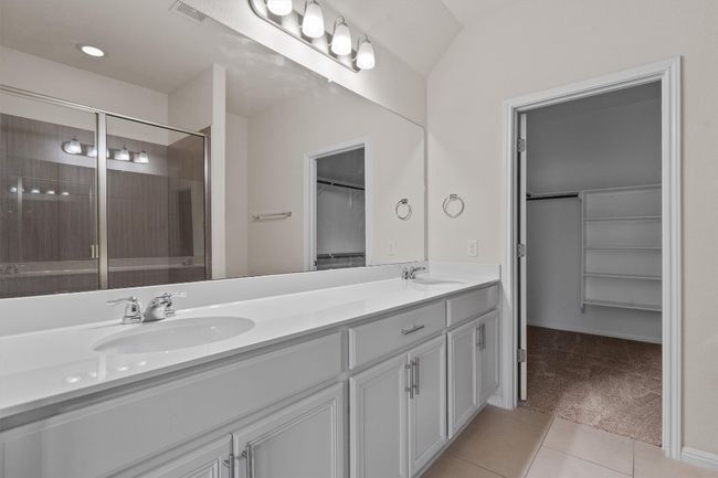 Full bathroom featuring double vanity, a walk in closet, tile patterned floors, and a shower stall | Image 17