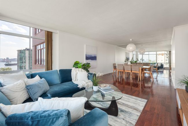 Living area with dark wood-style flooring, a wall of windows, and a city view | Image 16