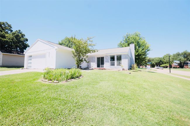 Ranch-style house featuring a chimney, a front lawn, concrete driveway, and an attached garage | Image 34