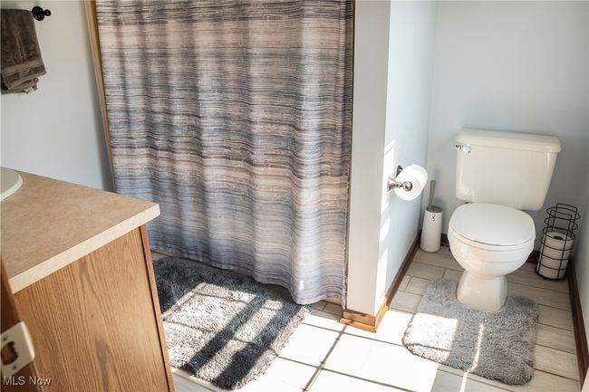 Bathroom with tile patterned floors, vanity, and curtained shower | Image 33